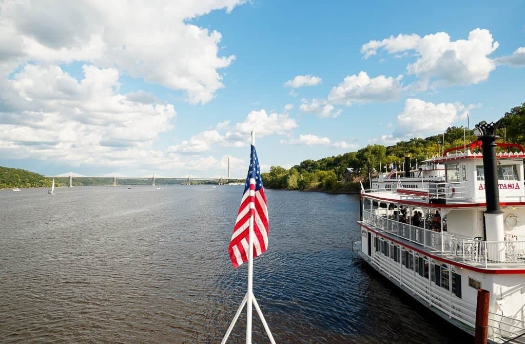 View up the St. Croix from a Stillwater riverboat, distant bridge in afternoon light.