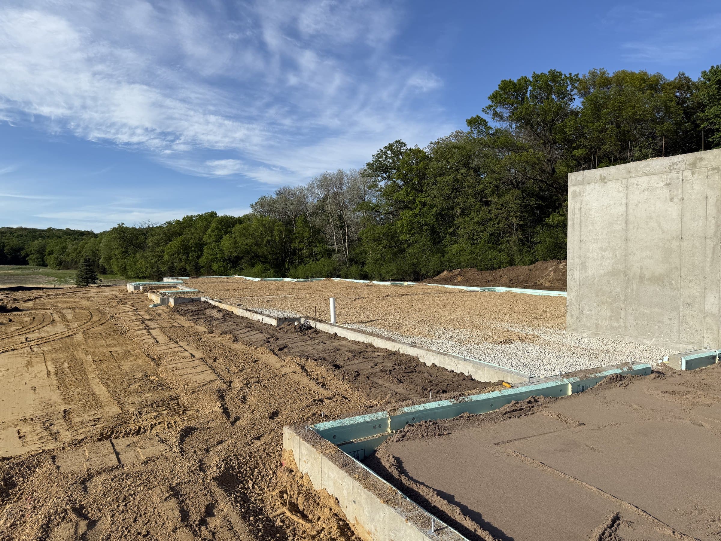 The finished foundation at Oakridge, open before the floor goes in, woods on every side.